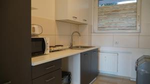 a kitchen with a sink and a microwave at MK Apartments Delmenhorst 1 - Free Wifi - Free Parking - nähe HBF in Delmenhorst