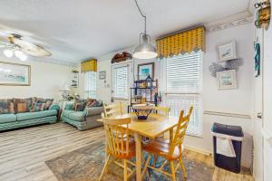a dining room and living room with a table and chairs at Beach Front #203 in Gulf Shores