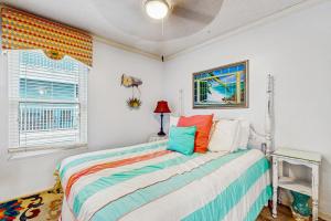 a bedroom with a bed with colorful pillows at Beach Front #203 in Gulf Shores