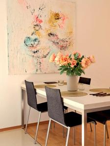 ein Esstisch mit einer Vase mit Blumen darauf in der Unterkunft Art & Living Apartment I nähe Frankfurt I Messe in Schöneck