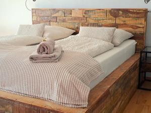 Bett mit einem Kopfteil aus Holz und einer Decke darauf in der Unterkunft Art & Living Apartment I nähe Frankfurt I Messe in Schöneck