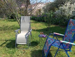 two chairs and a table in the grass at Chez Lia in Rieux-Minervois