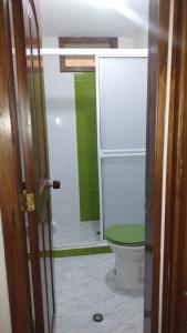a bathroom with a toilet with a green lid at Casa de Descanso Zapatoca in Zapatoca