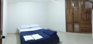 a bedroom with a bed with blue sheets and towels at Casa de Descanso Zapatoca in Zapatoca