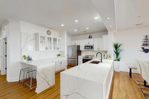 バージニアビーチにあるThe Sandbridge Dunes - Il Mare 111の白いキャビネットと白いカウンタートップを備えたキッチン