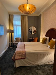 a hotel room with a large bed and a chandelier at Crystal Plaza Hotel in Stockholm