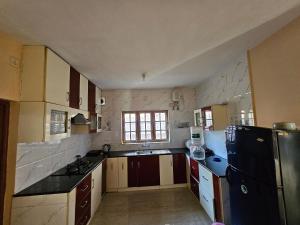 a kitchen with a black refrigerator and a sink at Mellowlux Ooty in Ooty