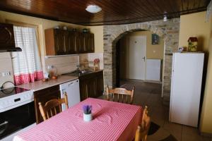 a kitchen with a table with a pink table cloth at Roža Apartments in Subotica