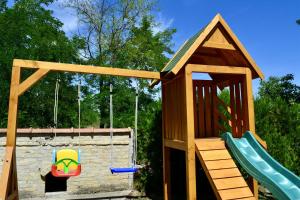 a playground with a swing and a play structure at Roža Apartments in Subotica