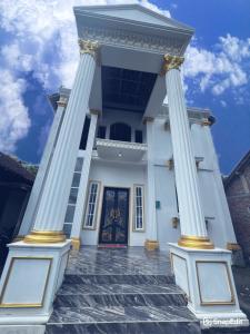a white building with columns in front of a door at Pendawi Putri Homestay Syariah Borobudur in Borobudur
