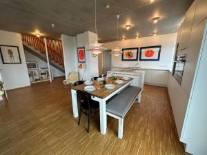 a kitchen and dining room with a table and chairs at Großzügiges modernes Ferienhaus in Neuharlingersiel