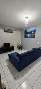 a living room with a blue couch in a room at Casa na Praia de Iracema R&S in Fortaleza