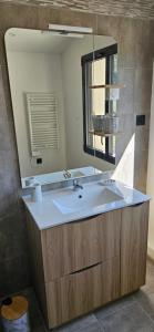 un baño con lavabo y espejo en Duplex 2 chambres avec extérieur, en Suze-la-Rousse 9 fotos más