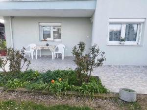 a patio with a table and chairs in front of a house at My Flowers in Árgos Orestikón