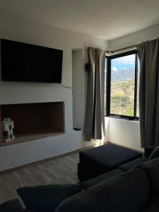 Una sala de estar con un sofá y una chimenea. en Dos Cumbres, en Ciudad Lujan de Cuyo