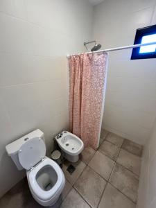 Un baño con inodoro y cortina de ducha. en Dos Cumbres, en Ciudad Lujan de Cuyo 6 fotos más