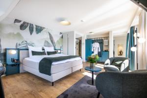 una camera da letto con un letto e un soggiorno di Hotel Central am See a Weggis