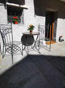 two chairs and a table in front of a building at La sosta ai Cantinitt in Megolo di Mezzo +15 photos