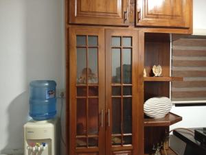 a wooden cabinet in a kitchen next to a refrigerator at Shan Villa in Negombo