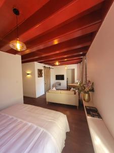 a bedroom with a white bed and a couch at Het Waterhof in Leiden