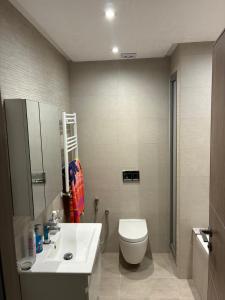 a bathroom with a white sink and a toilet at Moderne Appartement in Bellevue +10 photos