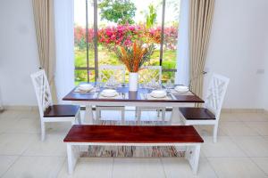 a dining room with a table and chairs and a window at Luxury Villa, Kalaa Homes Next to Vipingo Ridge, Kilifi, Kenya in Kilifi