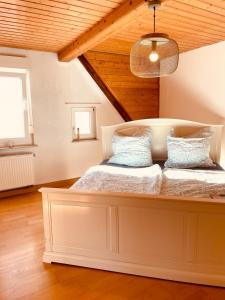 Un dormitorio con una gran cama blanca con almohadas azules. en Odw homes - charmantes Domizil im Gorxheimertal, en Kunzenbach
