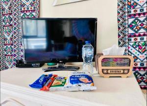a desk with a tv and snacks and a radio at BlueHostel in Cairo
