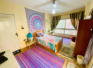 a bedroom with a bed and a large rug at BlueHostel in Cairo