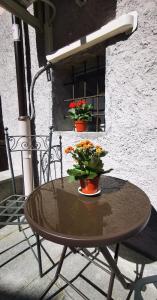 a small table with flowers on a patio at La sosta ai Cantinitt in Megolo di Mezzo