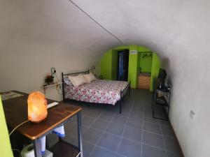 a bedroom with a bed and a table in a room at La sosta ai Cantinitt in Megolo di Mezzo
