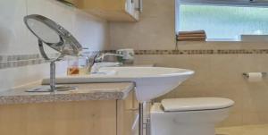y baño con lavabo y espejo sobre un aseo. en SainteMaxime PremiumVilla PrivatePool, en Sainte-Maxime