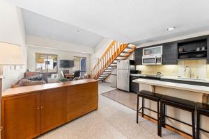 a kitchen and living room with a staircase in the background at Palisades Tahoe Lodge Rentals Studio Loft #356 in Olympic Valley