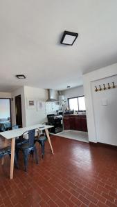 a room with a table and chairs and a kitchen at Departamento Pedernera in Godoy Cruz