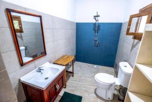 a bathroom with a sink and a toilet and a mirror at Mansa Musso Lodge in Sanyang