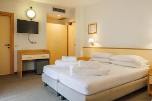 Łóżko lub łóżka w pokoju w obiekcie Club Hotel e Residence La Vela