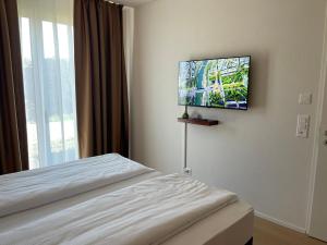 a hotel room with a bed and a flat screen tv at Hotel Swiss Bellevue Oberwangen in Oberwangen