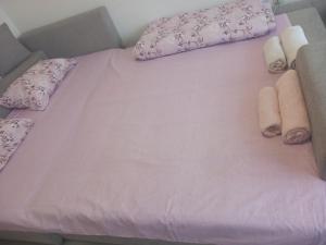 a pink bed with towels and pillows on it at Djordje in Belgrade