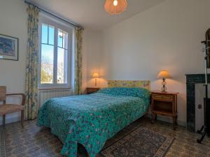a bedroom with a bed with a blue blanket and a window at Moulin paisible en Berry avec étang privé, proche du Château de Valençay et Zoo de Beauval - FR-1-591-18 in Chabris