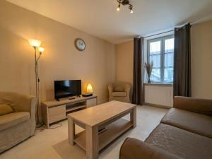 a living room with a television and a table at Maison de plain-pied en Brenne avec cour close, Wifi et proche de Châteauroux et étang de pêche - FR-1-591-104 in Neuillay-les-Bois