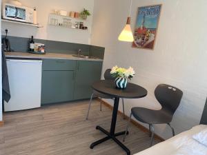 a small table with two chairs and a vase of flowers on it at Skansebakken 15 in Ebeltoft