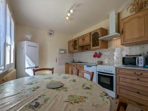 une cuisine avec une table et un réfrigérateur blanc dans l'établissement Charmante maison rénovée avec jardins à Berry - Proche de Châteauroux et La Châtre - FR-1-591-190, à Montipouret