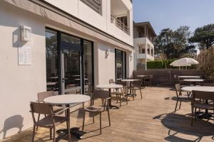 a row of tables and chairs outside of a building at Hotel 202 in Hossegor