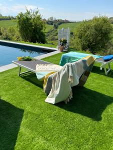 a bench on the grass next to a pool at Casa Sunset Hill Bologna in Bologna
