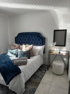 a bedroom with a bed with a blue headboard and a table at 11 on Korhaan Paternoster in Paternoster +47 photos