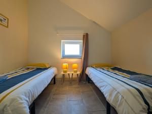 due letti singoli in una stanza con finestra di Gîte au cœur du Parc de la Brenne avec jardin, terrasse et parking - FR-1-591-317 a Migné