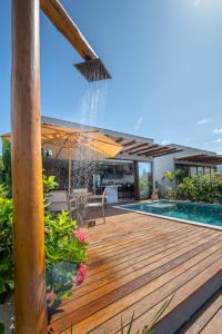 a pool with a wooden deck with a fountain at Casa Sol & Mar - Vila Kadosh in Barra Grande