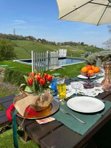 a picnic table with flowers and plates and an umbrella at Casa Sunset Hill Bologna in Bologna