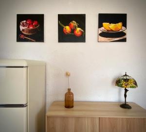 einen Tisch mit einem Kühlschrank und ein paar Fotos von Früchten in der Unterkunft La finestra sul parco Croara Country Club in Pieve Dugliara + 24 Fotos