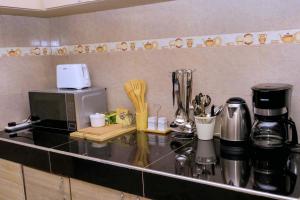 a kitchen counter with a microwave and some utensils at Kampala Hilltop Haven 2 Bedroom Gem in Kampala